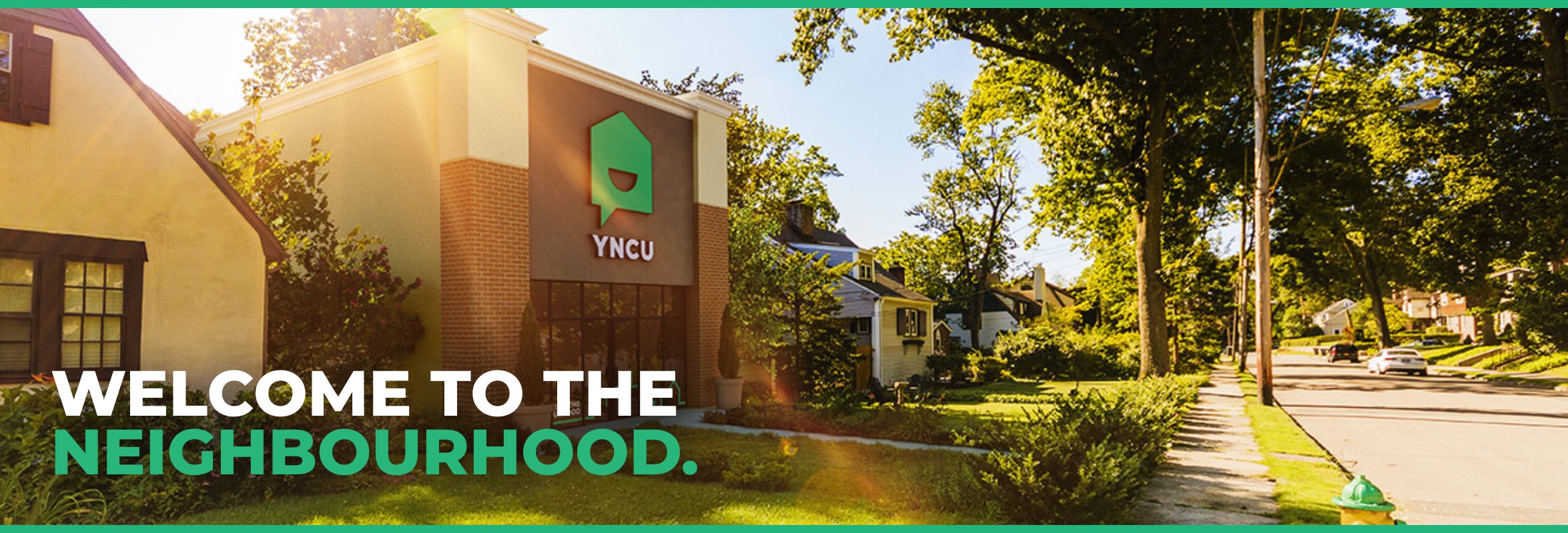 A YNCU branch sitting between two residential homes. Text reads "Welcome to the Neighbourhood."